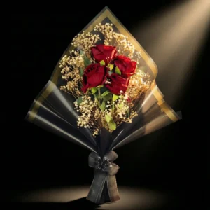siyah ambalaj içinde kırmızı yapay güller ve altın şeritli özel tasarım hediye buketi