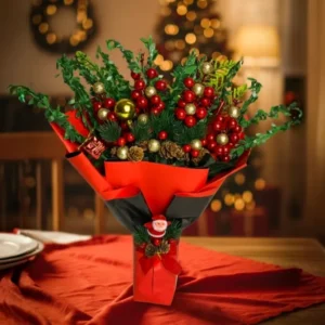 kırmızı ambalajlı noel baba figürlü altın toplu ve kozalaklı yapay kokina buketi